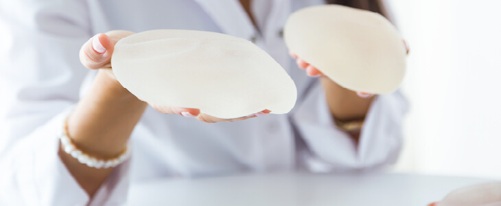 woman doctor holding breast implants